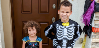 Two kids pose for a picture in their Halloween costumes