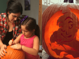 Diana helps her daughter carve a pumpkin for Halloween