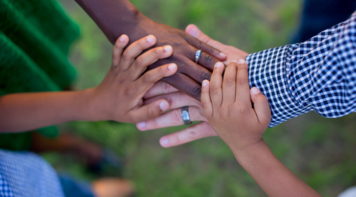 Giving Back on a Budget: An Activity for the Whole Family A family putting their hands together