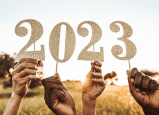Hands holding up numbers that read 2023