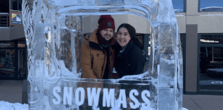 A couple poses for a picture in at ice sculpture in Snowmass, CO