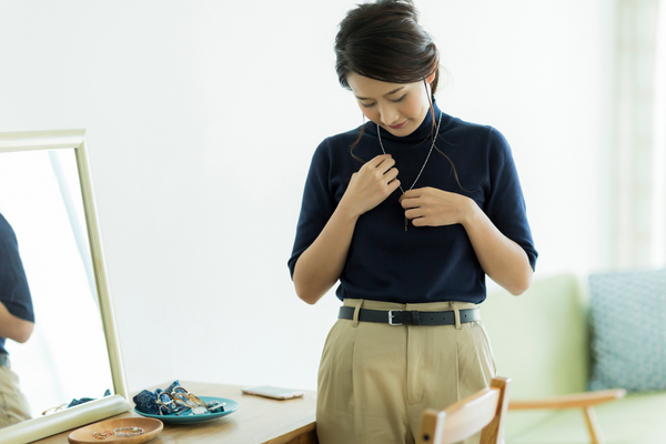 Image: A woman tries on a necklace