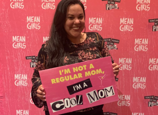 Image: Krystal holding a sign that reads, "I'm not a regular mom, I'm a cool mom."
