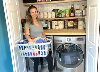 Image: Jessica stands in front of her washer and dryer with a basket of laundry