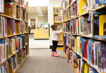 Image: A little girl peruses books at a library