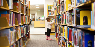 Read Across America: 5 Ways to Get Kids Excited About Reading Image: A little girl peruses books at a library