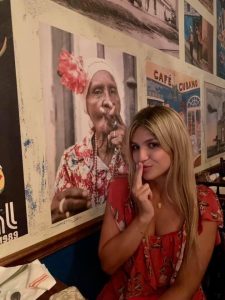 Image: Bella poses next to some artwork at Cafe La Trova