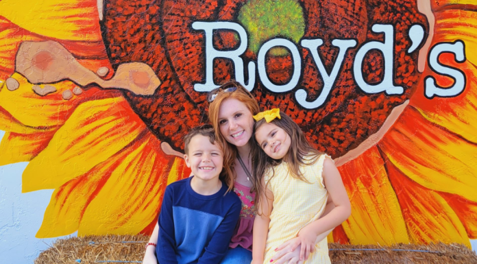 Image: Two kids and a mom sitting on a haystack at Royd's