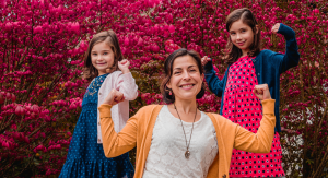 Image: A mom strikes a strong pose with her daughters
