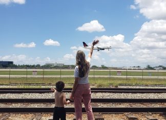 Image: A mother and son wave to an airplane as it lands at MIA