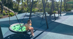 Image: A little girl enjoys a saucer swing at a local park in Homestead