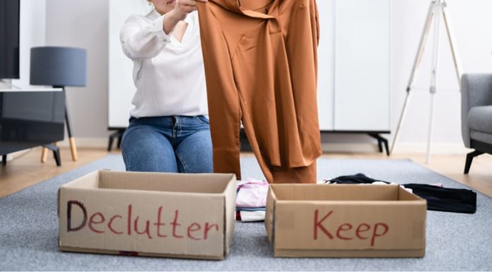 Image: A woman sorts clothing into boxes labeled "declutter" and "keep" as a way to give back
