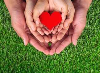 Image: Three sets of hands holding a red heart