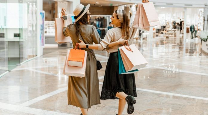 Image: 2 women carrying shopping bags while they shop together