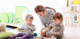 Image: A babysitter watches two toddlers play