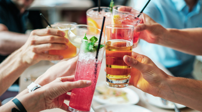 Image: A group of people doing cheers with alcoholic beverages