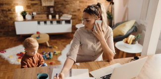 Image: A mom working from home while her toddler plays beside her