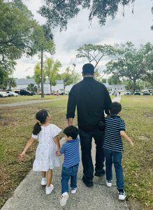 Image: A father walking with his 3 kids