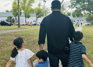 Image: A dad walking with his 3 children