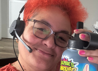 Image: Natasha Arias sits at her desk with a headset, ready for work