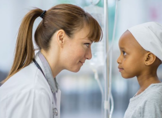Image: A doctor kneels down to eye level with a pediatric patient