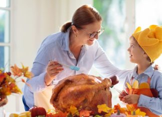 Image: A grandmother bastes a Thanksgiving turkey with a grandchild