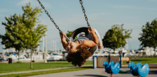 Winter Break in Miami: A Bucket List & To Do List for Miami Moms Image: A little girl in a toddler swing at a playground