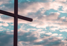 5 Simple, Meaningful Ways to Share the Gospel With Your Kids Image: A large cross silhouetted against a cloudy daytime sky