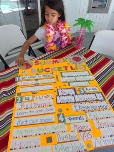 Image: A child next to their family's finished summer bucket list