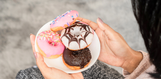 Weight Loss: Why Your Sugar Habits Might be Holding You Back Image: A woman holding a plate of donuts