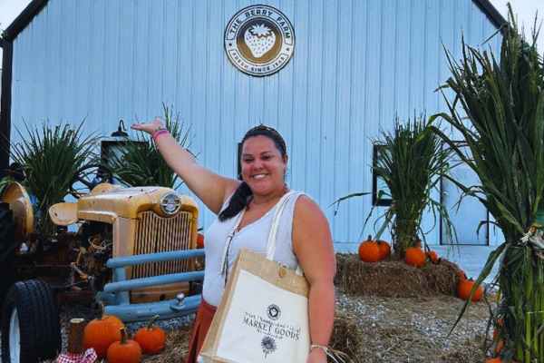 Image: Krystal poses for a photo in front of a fall-themed display at The Berry Farm