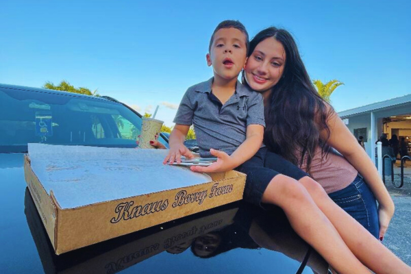 Image: A brother and sister with a box of cinnamon rolls at Knauss Berry Farms
