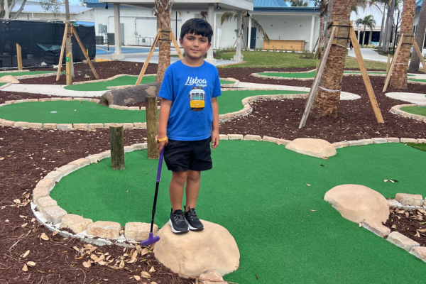 Image: A child enjoying a mini golf course
