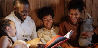 Black History Month Picture Books to Read With Kids Image: A father and mother enjoy a picture book with their daughter and son