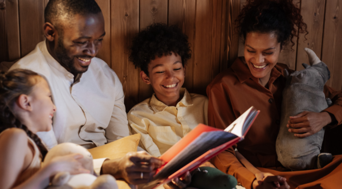 Black History Month Picture Books to Read With Kids Image: A father and mother enjoy a picture book with their daughter and son