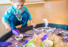 Sensory Play: A Mom’s Guide to Supporting Child Development Image: A little girl plays with a large sensory mat